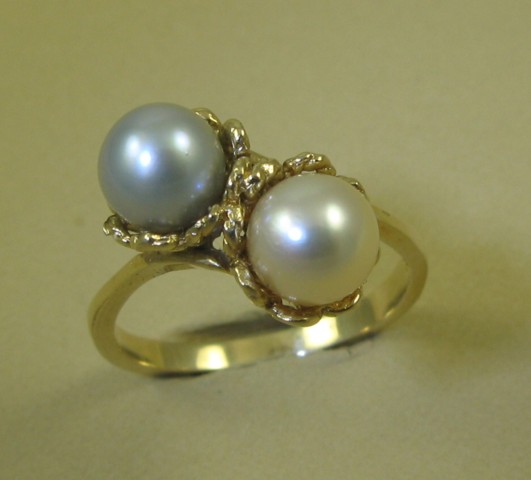 Appraisal: PEARL AND FOURTEEN KARAT GOLD RING set with two round