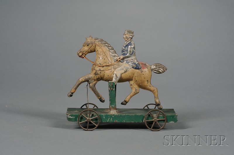 Appraisal: Polychrome Painted Pressed Tin Horse and Rider Pull Toy America