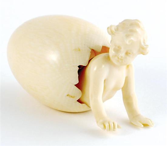 Appraisal: Carved ivory egg with putti late th century infant emerging