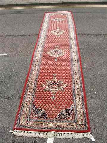 Appraisal: AN ORIENTAL RUNNER of Persian serab design wine red field