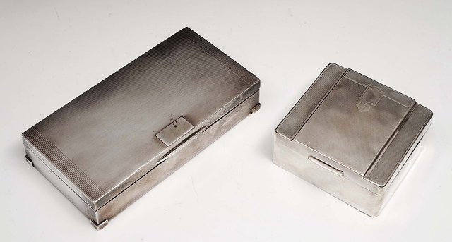 Appraisal: Two silver cigarette boxesin the Art Deco style with engine