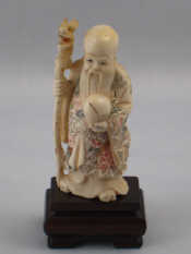 Appraisal: A signed Chinese ivory figure of a traveller with a