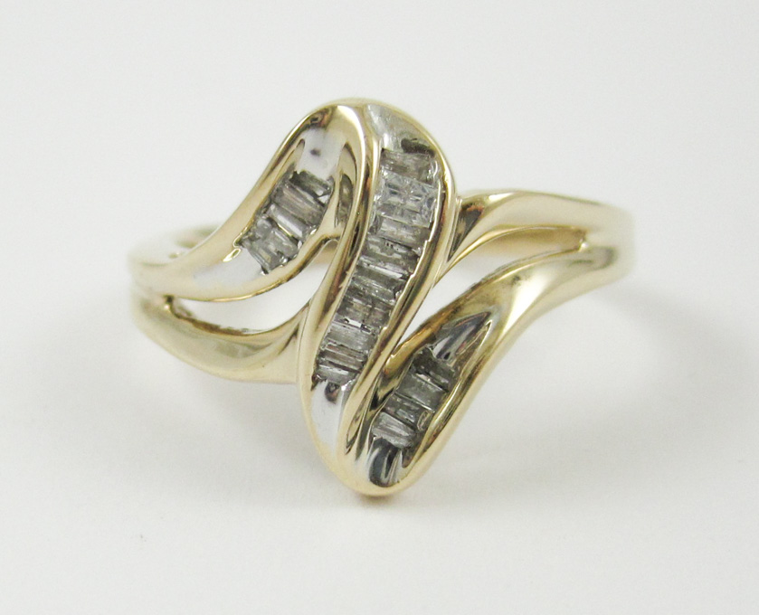 Appraisal: DIAMOND AND TEN KARAT GOLD RING with tapered baguette channel