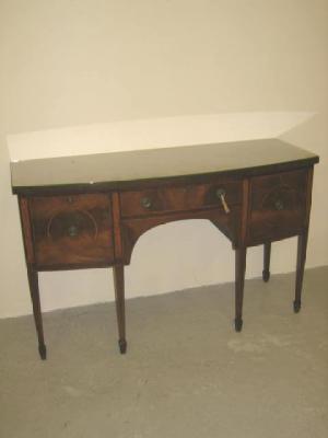 Appraisal: A MAHOGANY SIDEBOARD of bowed form crossbanded with stringing banded