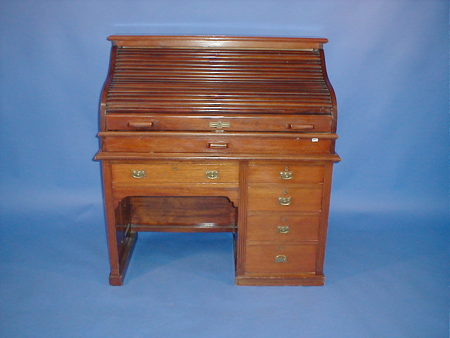 Appraisal: An Edwardian walnut roll top desk with S-shape tambour kneehole