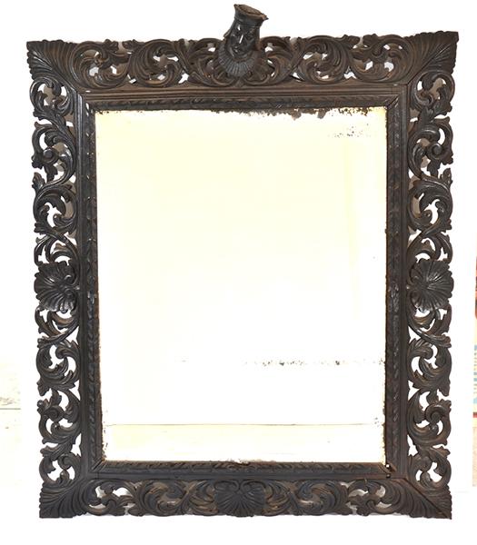 Appraisal: A CARVED AND PIERCED WALL MIRROR WITH KINGS HEAD FINIAL