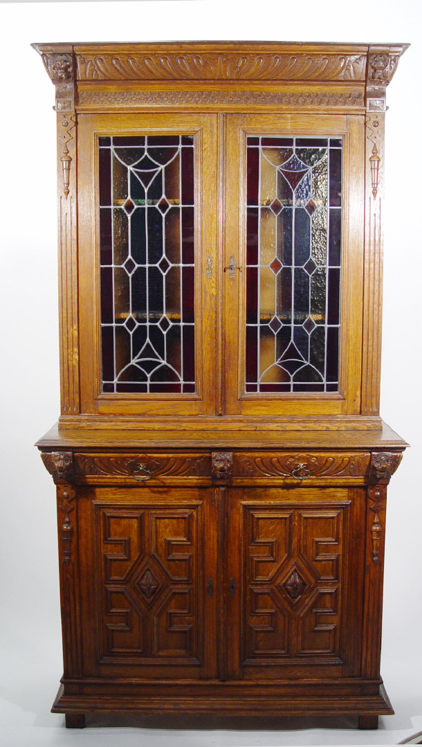 Appraisal: Heavily carved oak bookcase the cornice flanked by lion mask