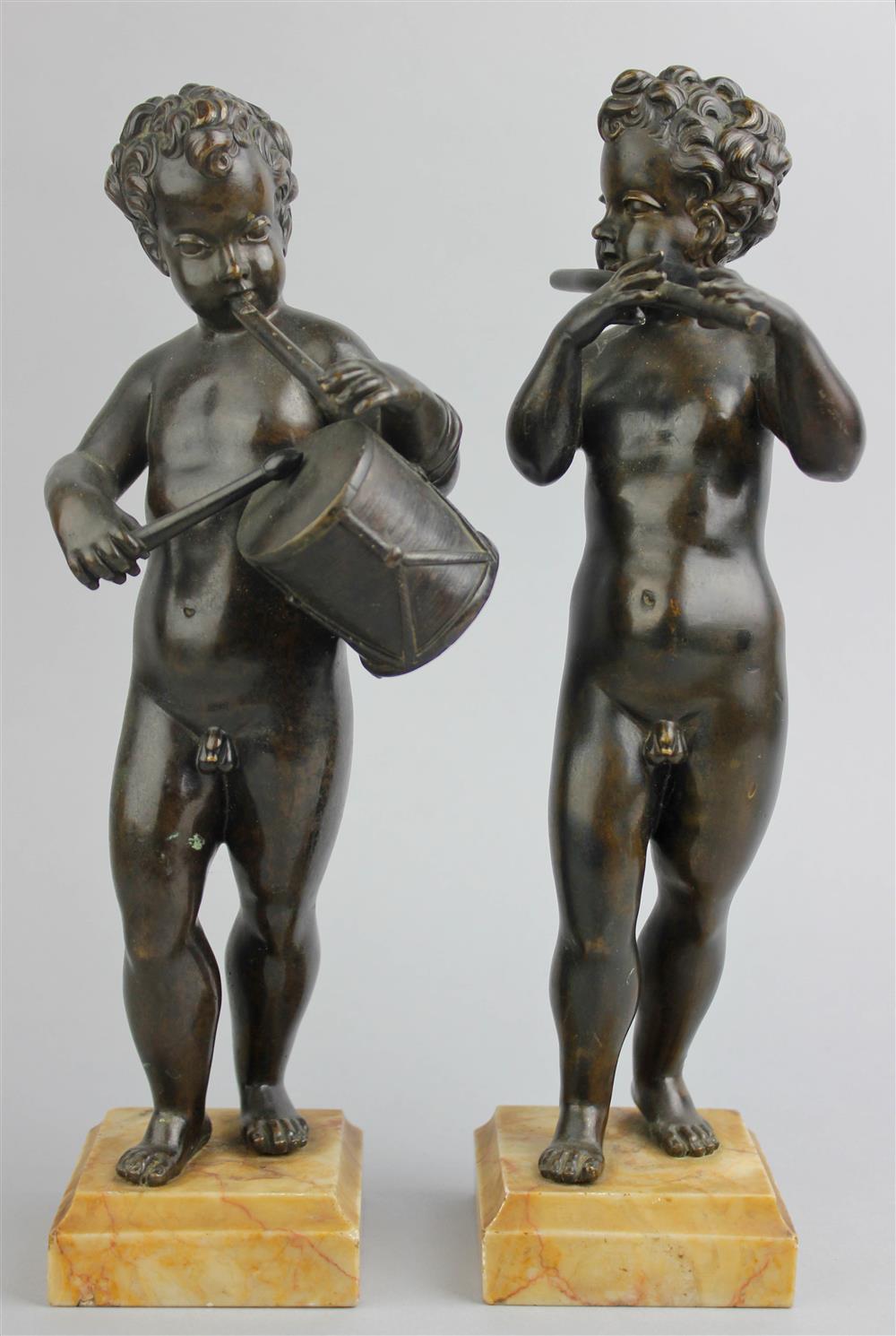 Appraisal: PAIR OF BRONZE PUTTI PLAYING MUSICAL INSTRUMENTS AFTER MODELS BY