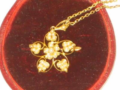 Appraisal: AN EDWARDIAN SEED PEARL PENDANT BROOCH modelled as a flowerhead