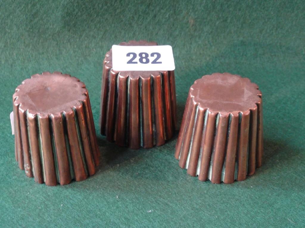 Appraisal: A set of three miniature copper jelly moulds with fluted