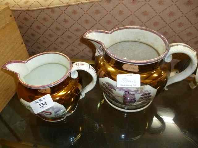 Appraisal: TWO GRADUATED LUSTRE WARE JUGS with scrolling handles and inset