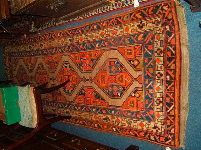 Appraisal: A multi-coloured ground Persian rug with four stylised diamond motifs