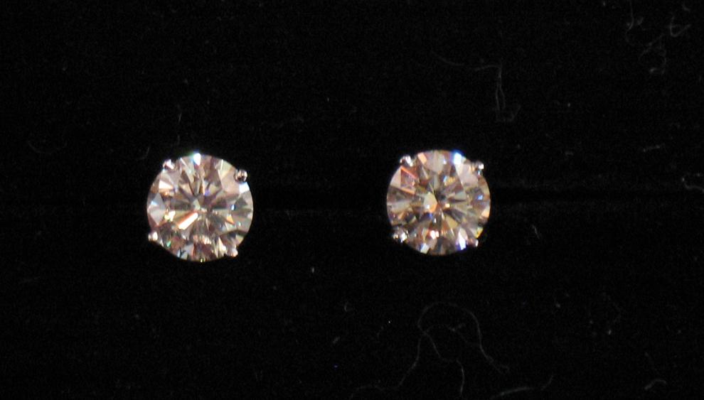 Appraisal: A PAIR OF DIAMOND SOLITAIRE EAR STUDS the central round