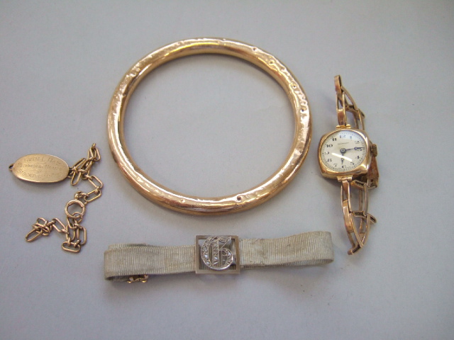 Appraisal: A gold circular hollow bangle a gold identity bracelet a