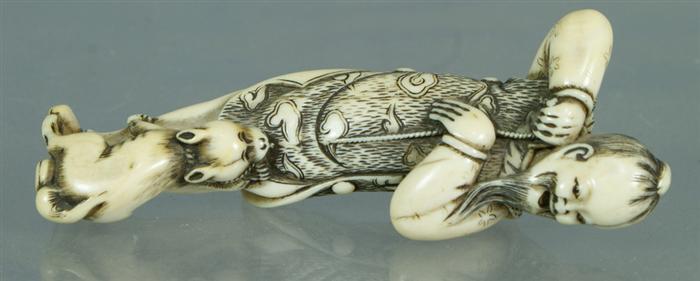 Appraisal: Japanese carved ivory netsuke depicting a man with dog approx