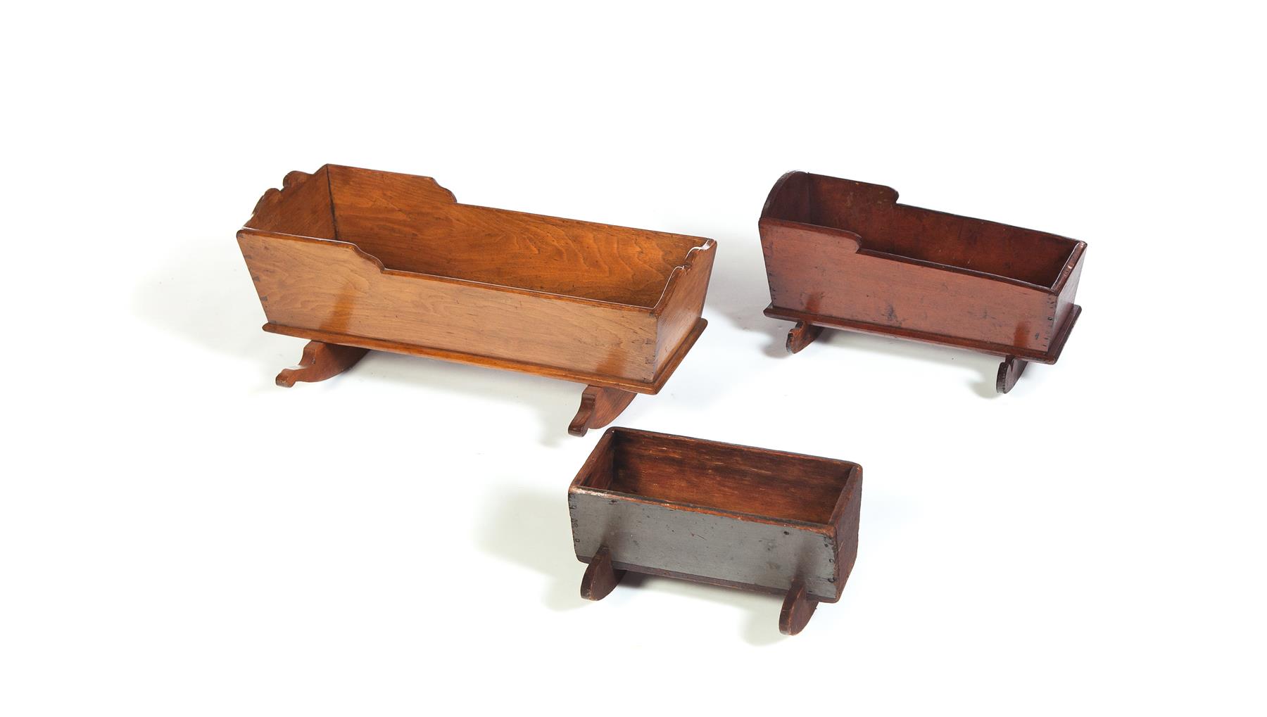 Appraisal: THREE TH-CENTURY DOLL CRADLES Cherry l and walnut l Together