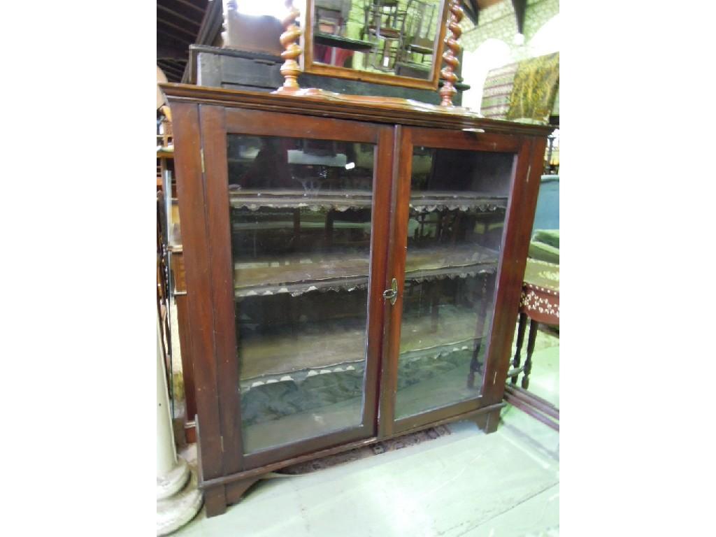 Appraisal: An Edwardian walnut bookcase enclosed by a pair of glazed