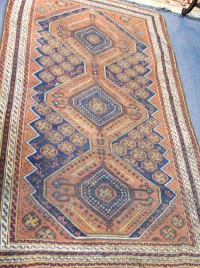 Appraisal: AN OLD PERSIAN RUST GROUND RUG decorated a triple diamond