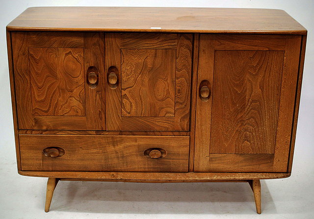 Appraisal: A LIGHT ELM ERCOL SIDEBOARD with three cupboards and one