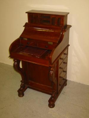 Appraisal: A VICTORIAN WALNUT DAVENPORT the down curved lid opening to