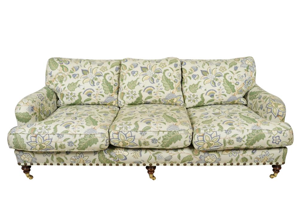 Appraisal: CUSTOM FLORAL LINEN-UPHOLSTERED SOFAwith turned wood legs on casters inches