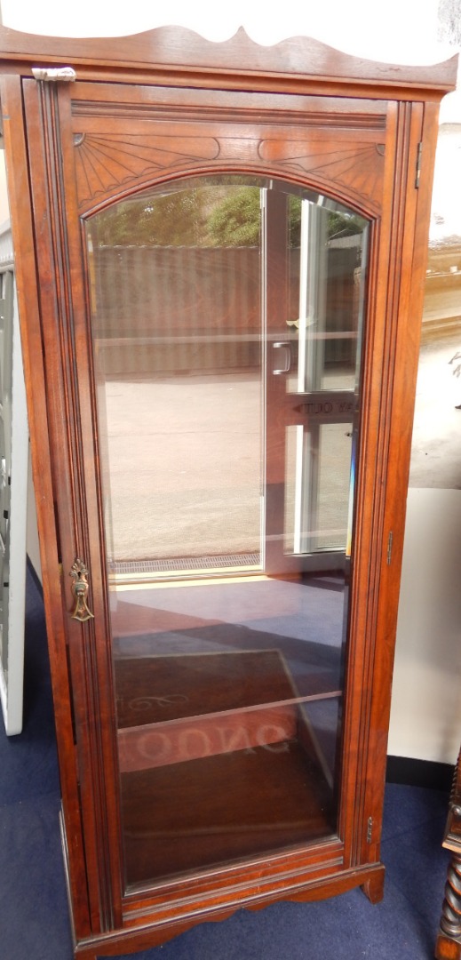 Appraisal: An Edwardian walnut cabinet with three shelves enclosed by a