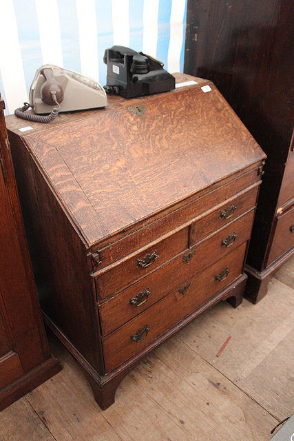 Appraisal: A GEORGE III OAK BUREAU the fall front enclosing a