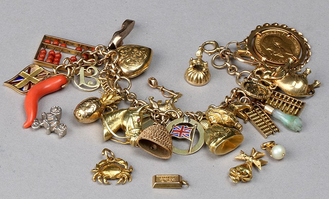 Appraisal: A GOLD CHARM BRACELET with twenty two attached varying charms