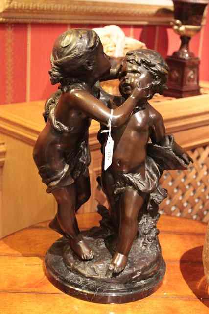 Appraisal: A BRONZE SCULPTURE OF TWO PUTTI embracing on a circular