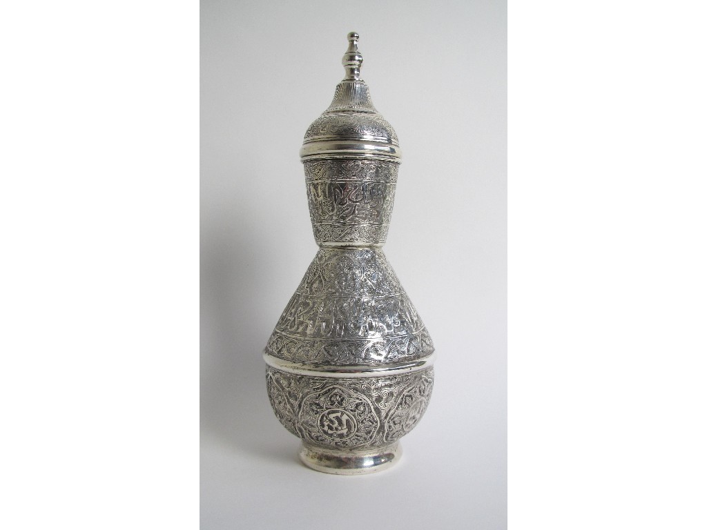 Appraisal: An Islamic white metal bottle shaped vase and cover chased