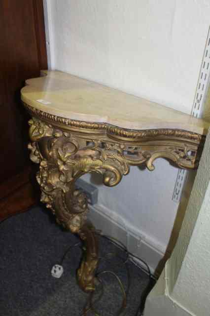 Appraisal: A FRENCH GILT PLASTER CONSOLE TABLE with a shaped marble