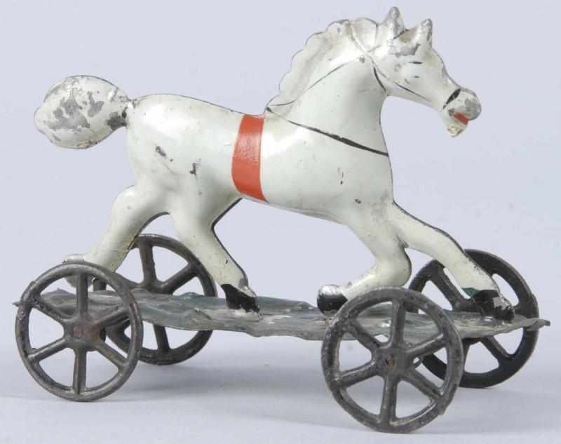 Appraisal: Handpainted Tin Horse on Platform Toy Description American Iron wheels