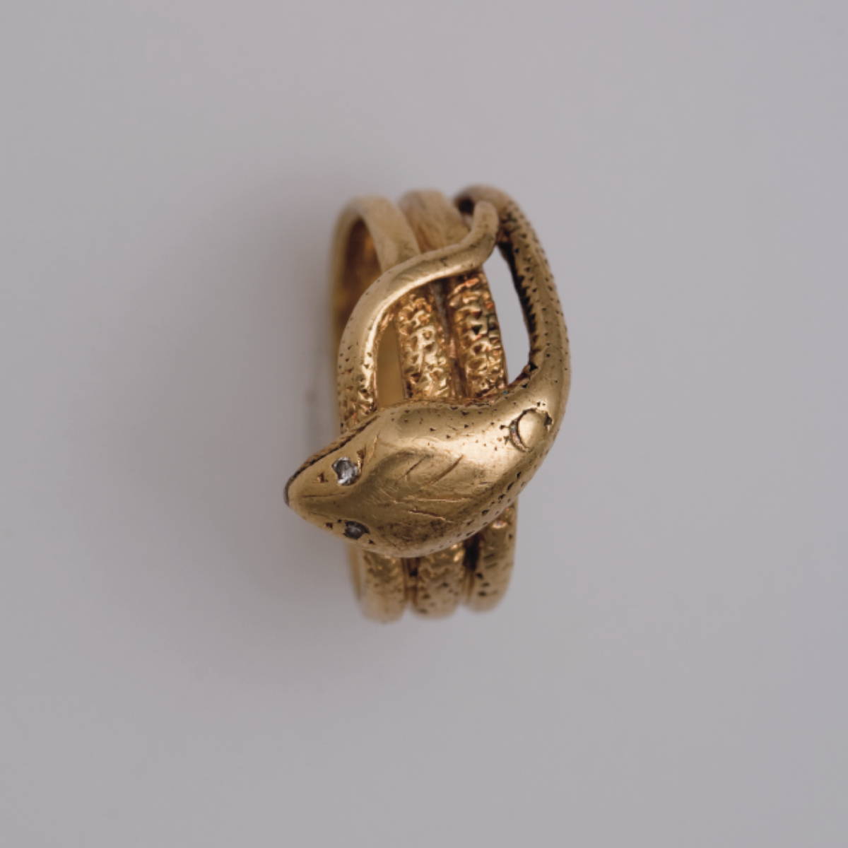 Appraisal: GOLD SNAKE RING The snake head accented with ruby eyes