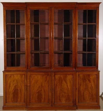 Appraisal: REGENCY MAHOGANY BREAKFRONT BOOKCASE The molded cresting above glazed doors