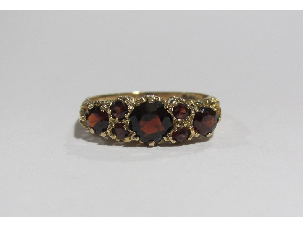 Appraisal: A nine carat gold garnet seven stone ring