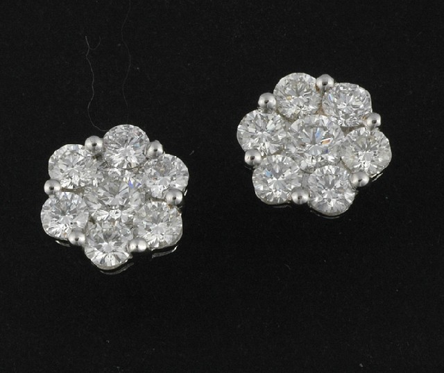 Appraisal: A PAIR OF DIAMOND FLOWER CLUSTER EARRINGS Having a central