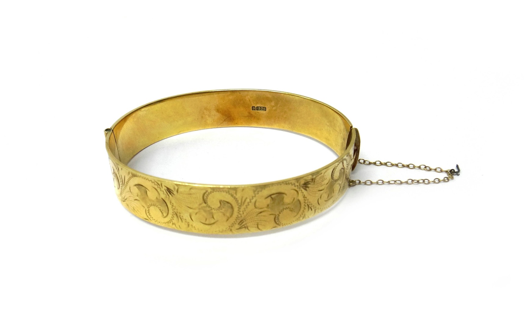 Appraisal: A ct gold oval hinged bangle the front with feathered