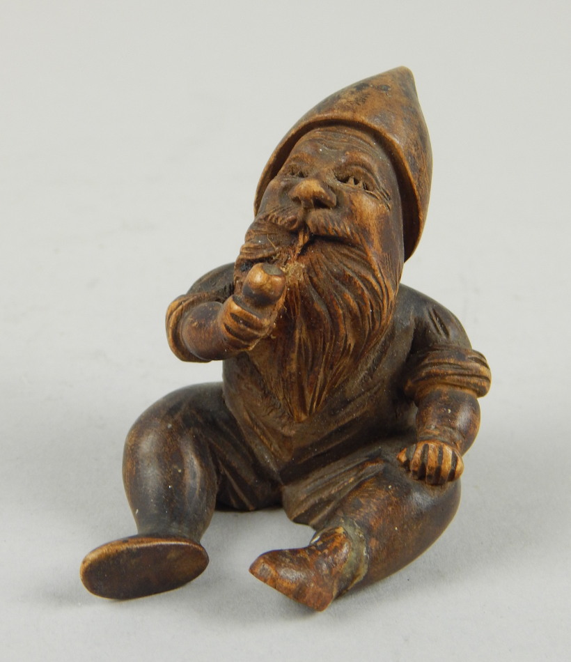 Appraisal: A thC heavily carved miniature figure of a seated gnome