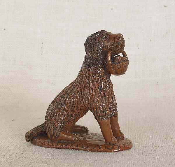 Appraisal: Pennsylvania redware seated dog th c clutching a basket of