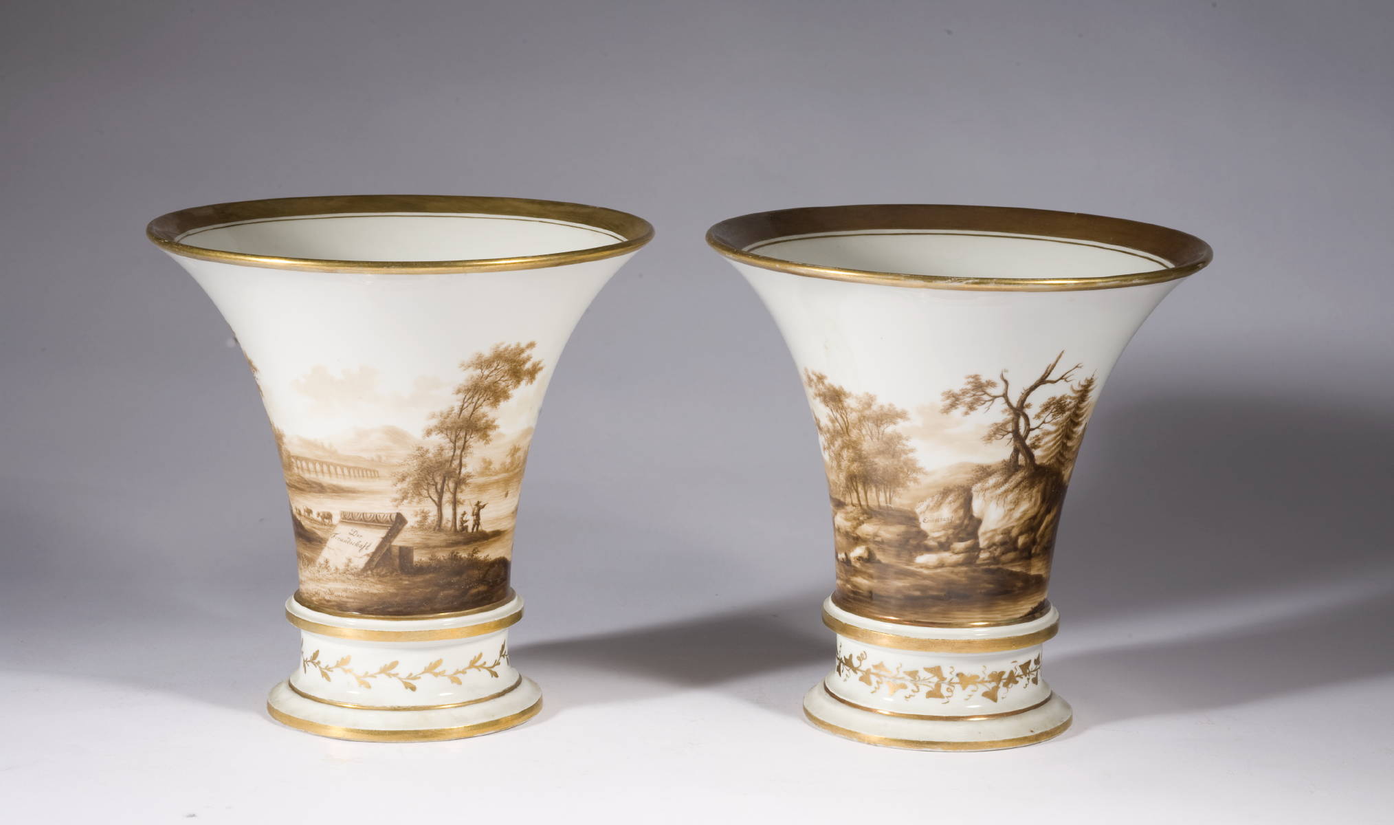 Appraisal: PAIR OF GERMAN PORCELAIN BEAKER FORM VASES WITH SEPIA LANDSCAPE