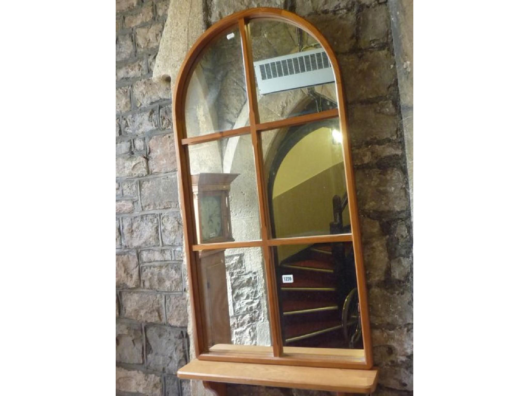 Appraisal: A modern stripped pine framed hall mirror of arched form