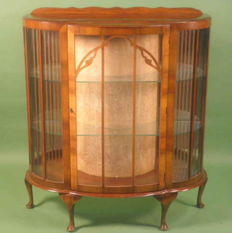 Appraisal: A walnut veneered bow fronted Art Deco style display cabinet