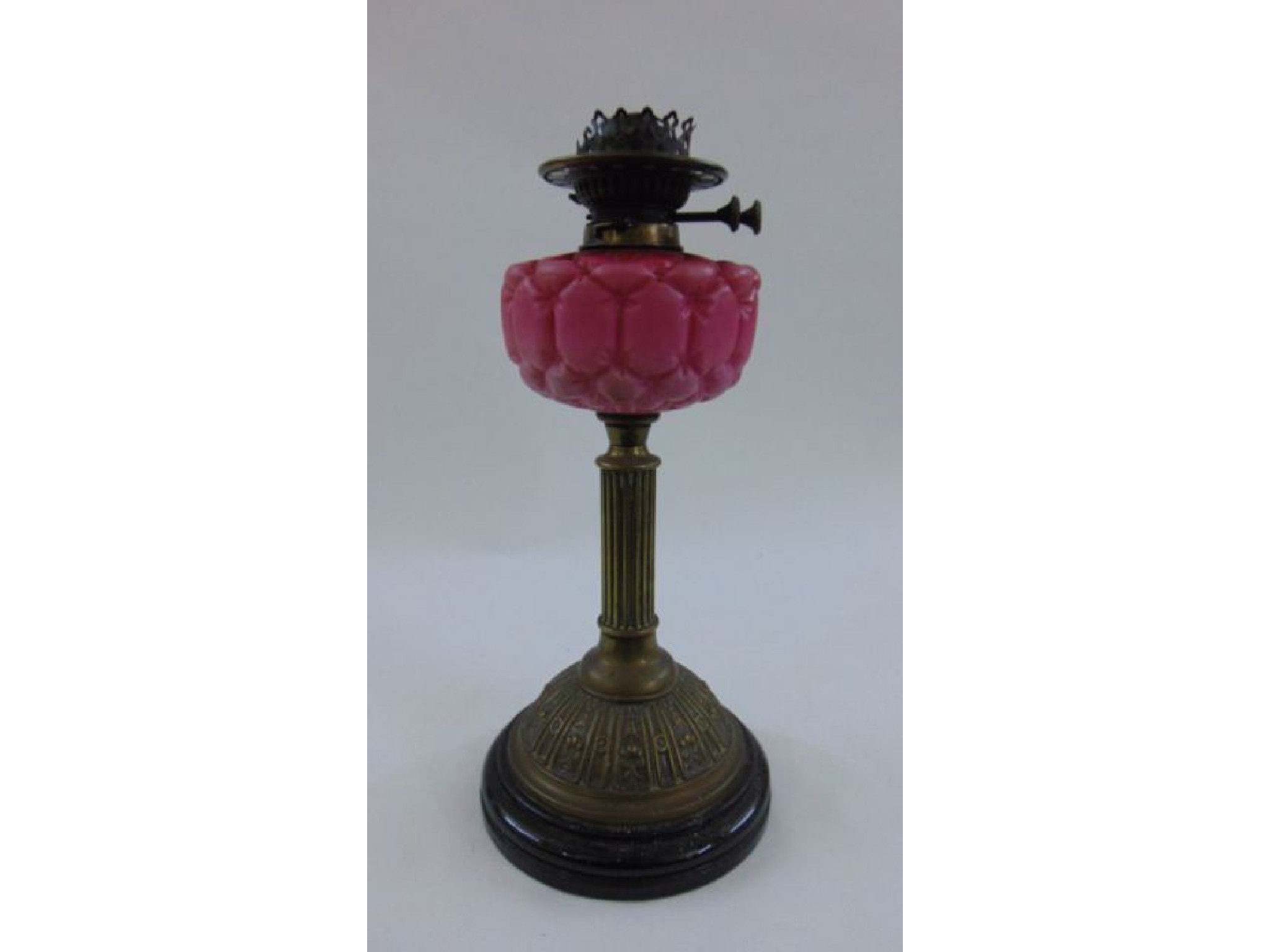 Appraisal: A Victorian embossed brass oil lamp with satin glass font