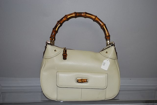 Appraisal: Gucci bone leather handbag with zip top front pocket and