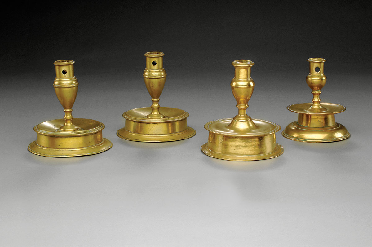 Appraisal: FOUR CONTINENTAL BRASS CANDLESTICKS Each tapered stem above a medial