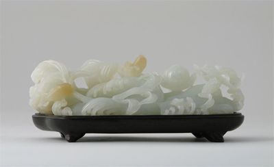 Appraisal: A Chinese white jade carving of swirling waves entwined with