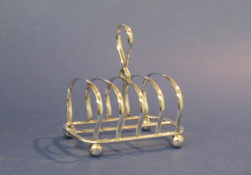 Appraisal: A TOASTRACK of five bars with central loop carrying handle