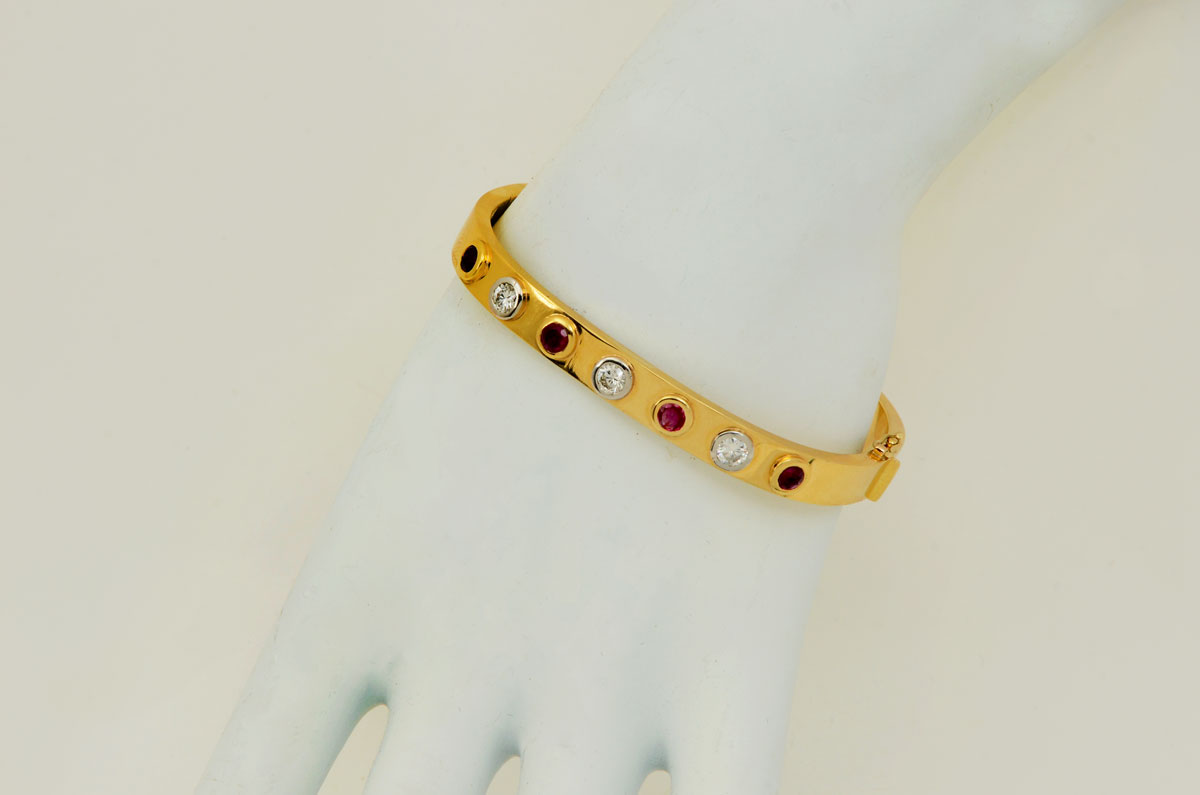 Appraisal: K SQUARE BANGLE WITH RUBIES DIAMONDS Yellow gold is the