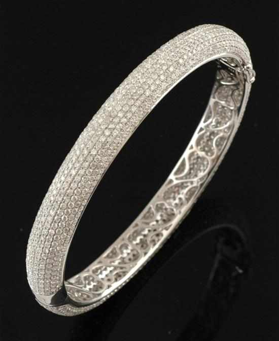 Appraisal: A diamond bangle The hinged bangle pave set with round