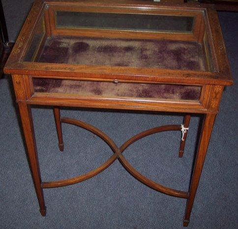 Appraisal: An Edwardian inlaid satinwood glass panelled display table on square